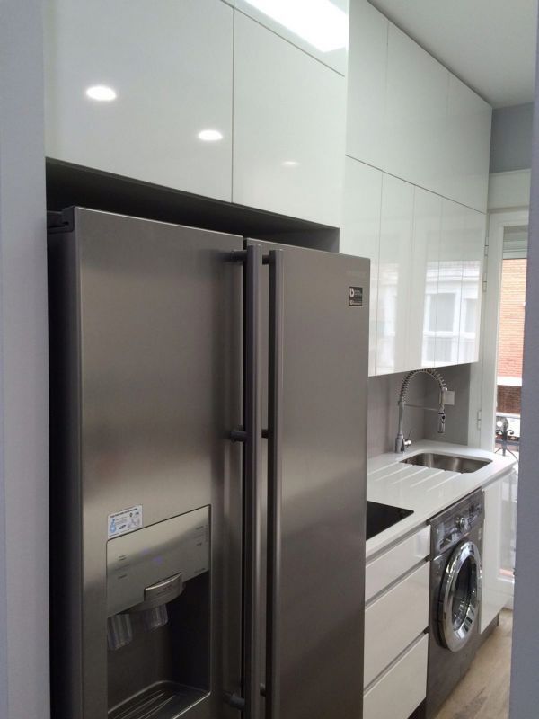 Frigorífico dos puertas insertado en cocina de color blanco