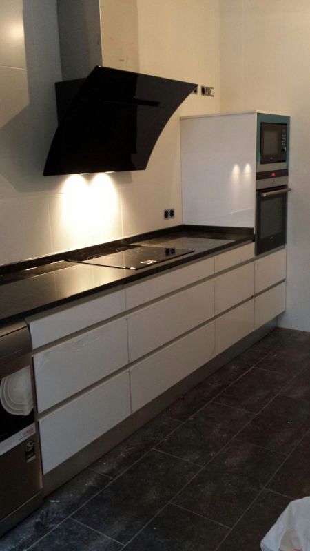 Cocina de color blanco con gran campana de extracción